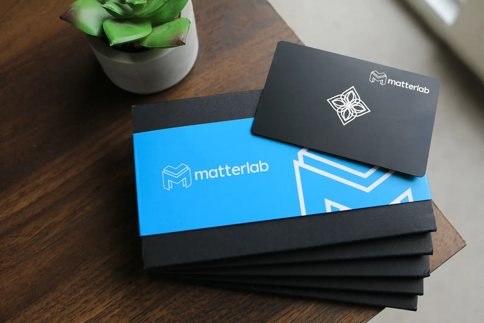 A stack of Bloom keycards engraved with a company logo, with branded packaging